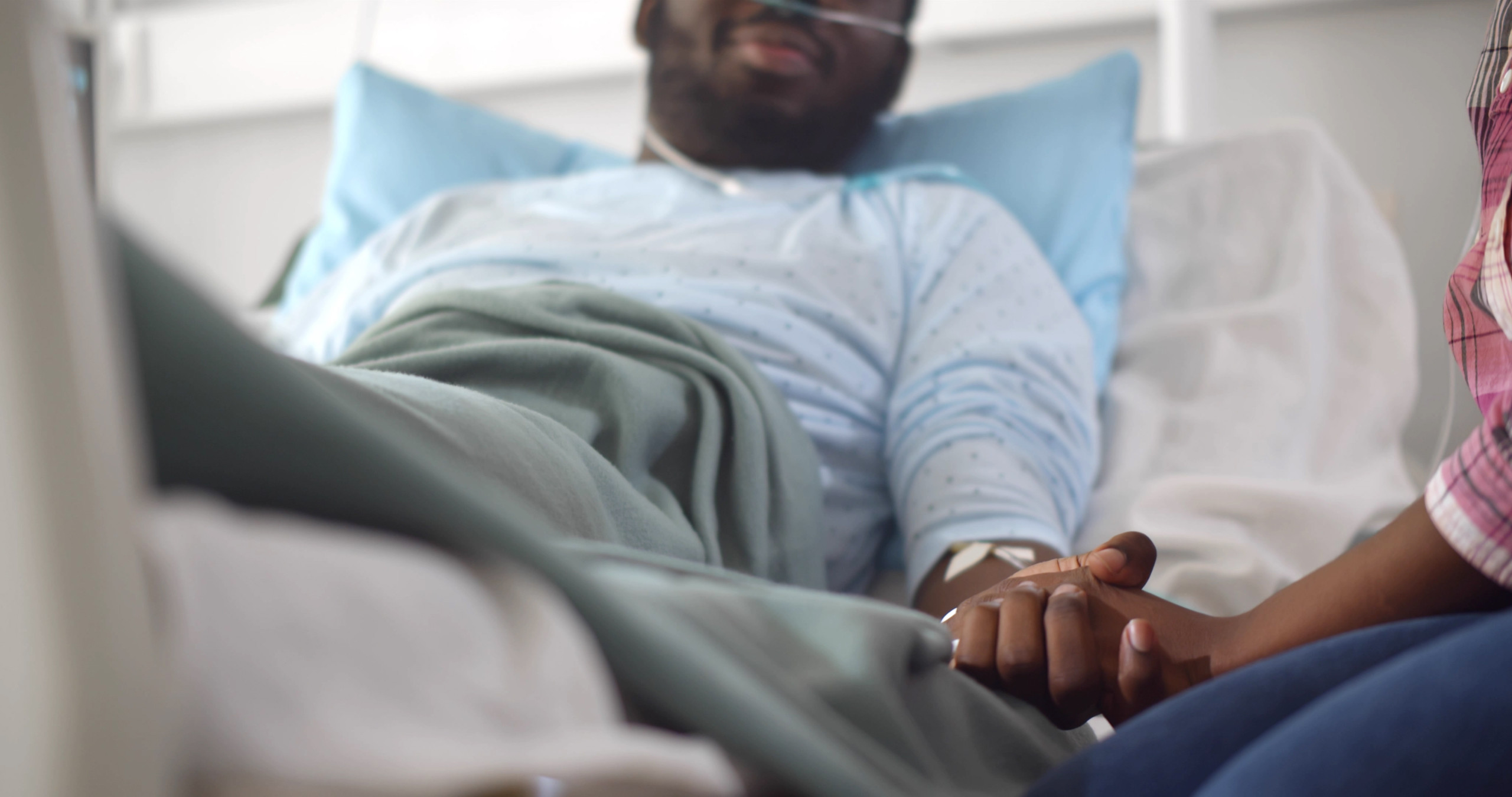 Cropped,Shot,Of,African,Wife,Visiting,Husband,In,Hospital,Holding Male nurse with male patient in hospital gown.